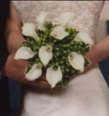 Leslie holds her beautifully decorated calla lily bridal bouquet