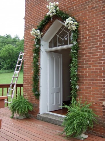 The white roses and wax flower arrangements are silk