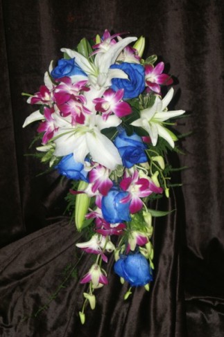 This tropical cascading wedding bouquet is filled with purple orchids blue 